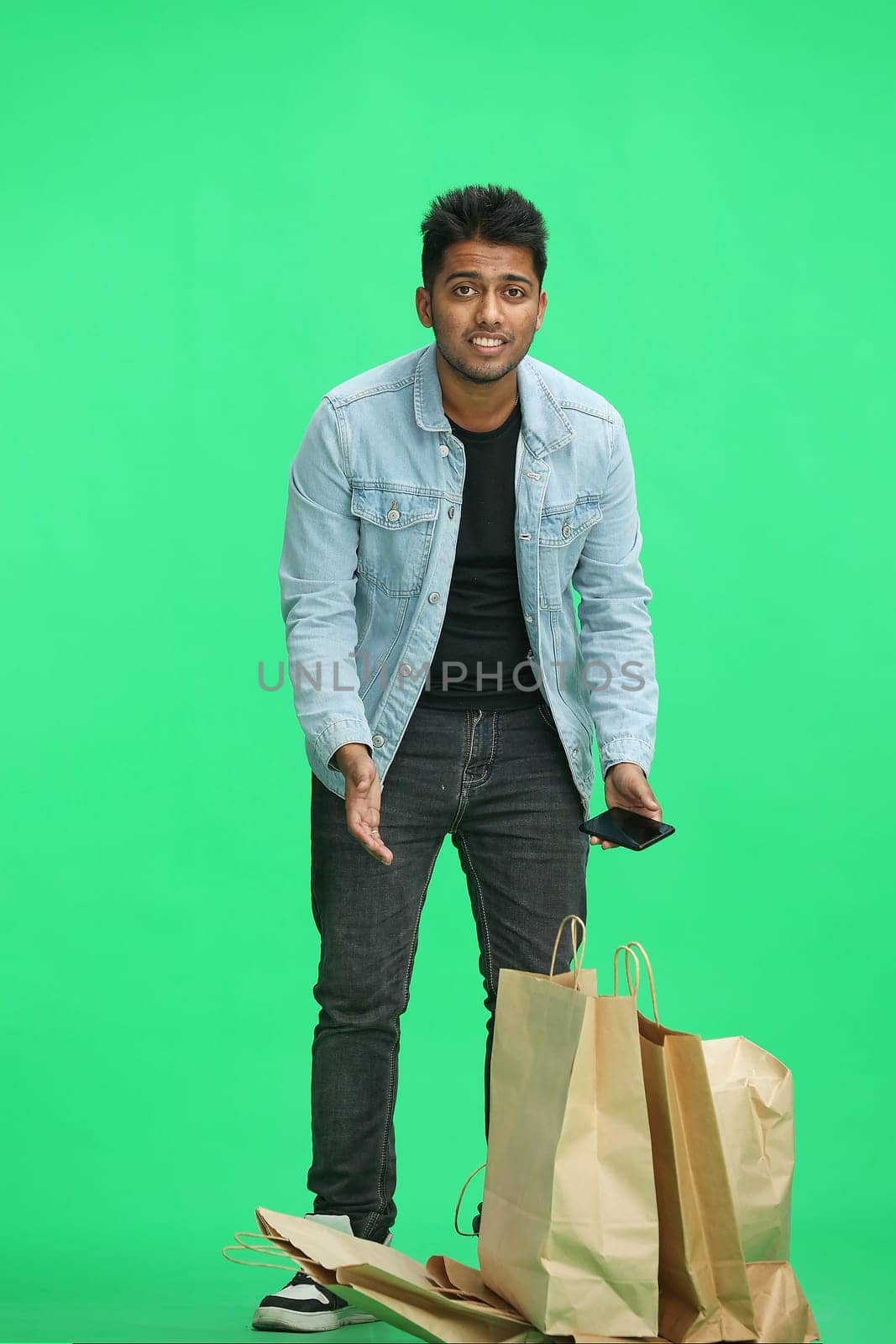 Man on a green background with shoppers.