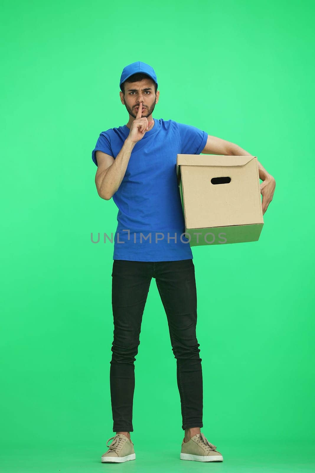 A man on a green background with box show silence sign by Prosto