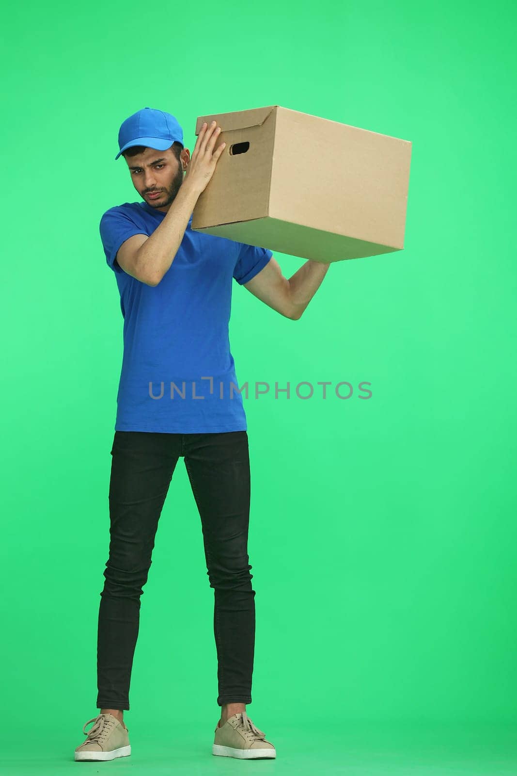 A man on a green background with box up.