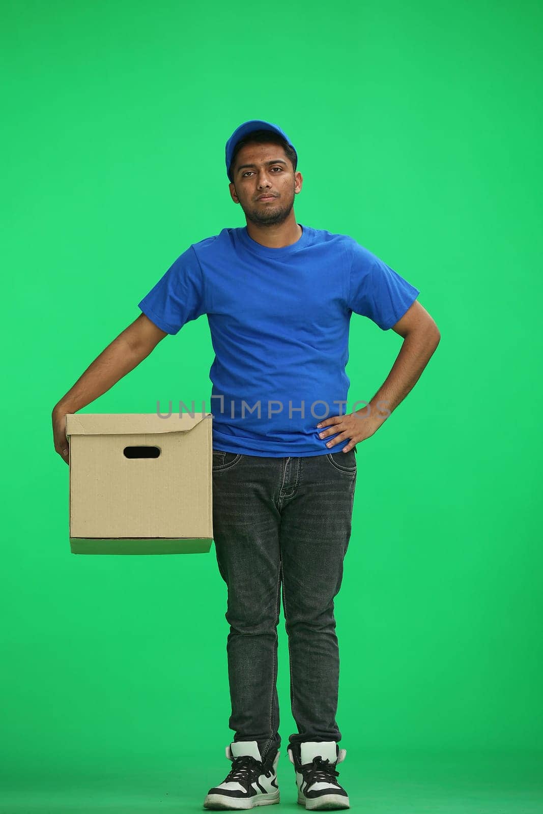 A man on a green background with box wait.