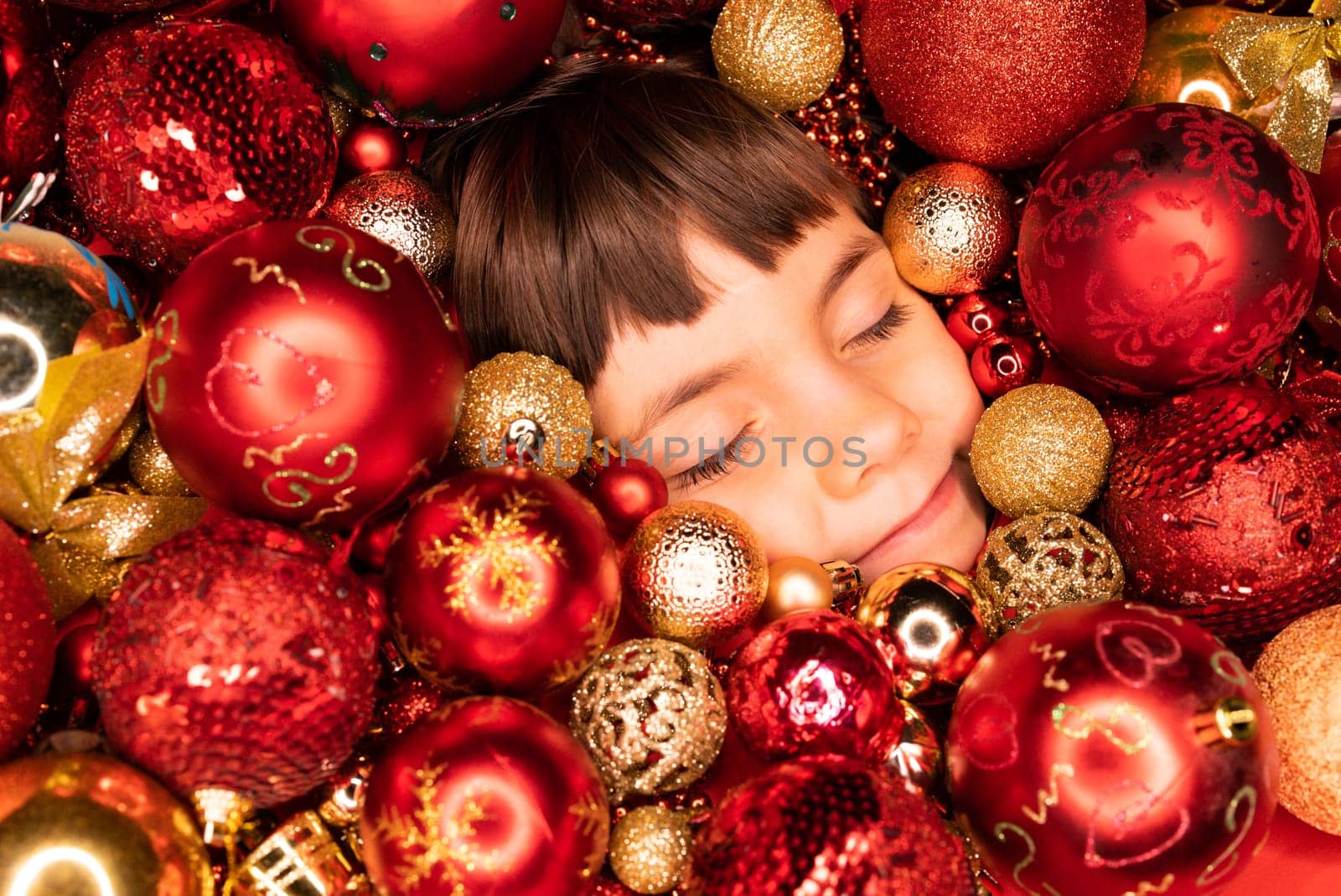 Toddler boys face lights up with joy in Christmas tree toys balls. Wonder, happiness mood. Touch of magic Holiday-themed projects, family-focused content or sentimental storytelling.