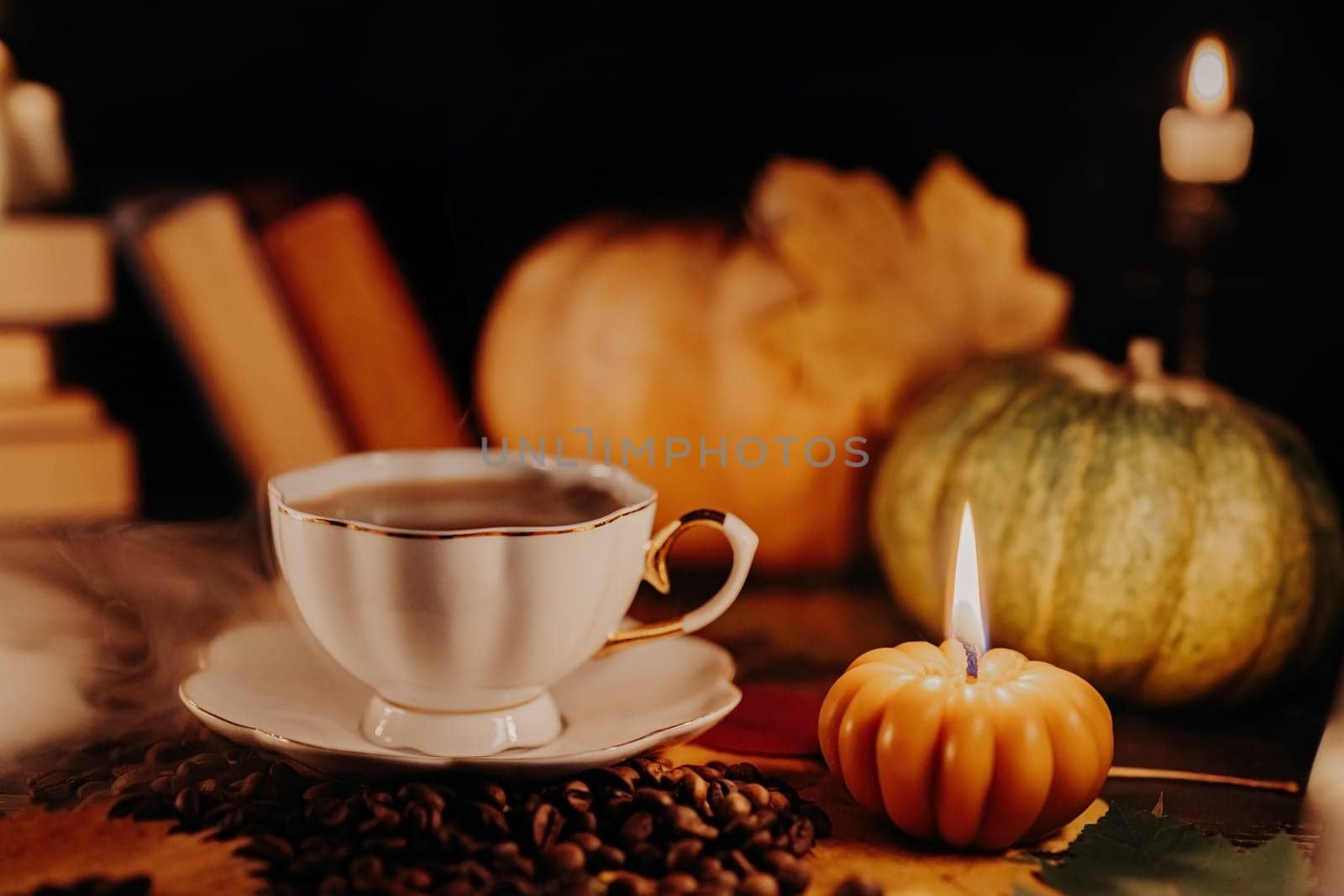 Porcelain coffee cup among pumpkin candles. Autumn-themed content, cafe promotions or visual storytelling that exudes comfort. Touch of intimacy, tranquil and inviting hygge atmosphere.