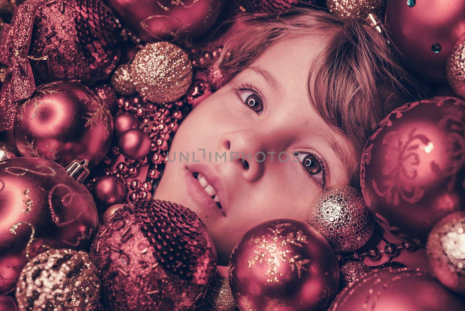 Toddler boys face in Christmas tree toys balls. Wonder, happiness mood by kristina_kokhanova