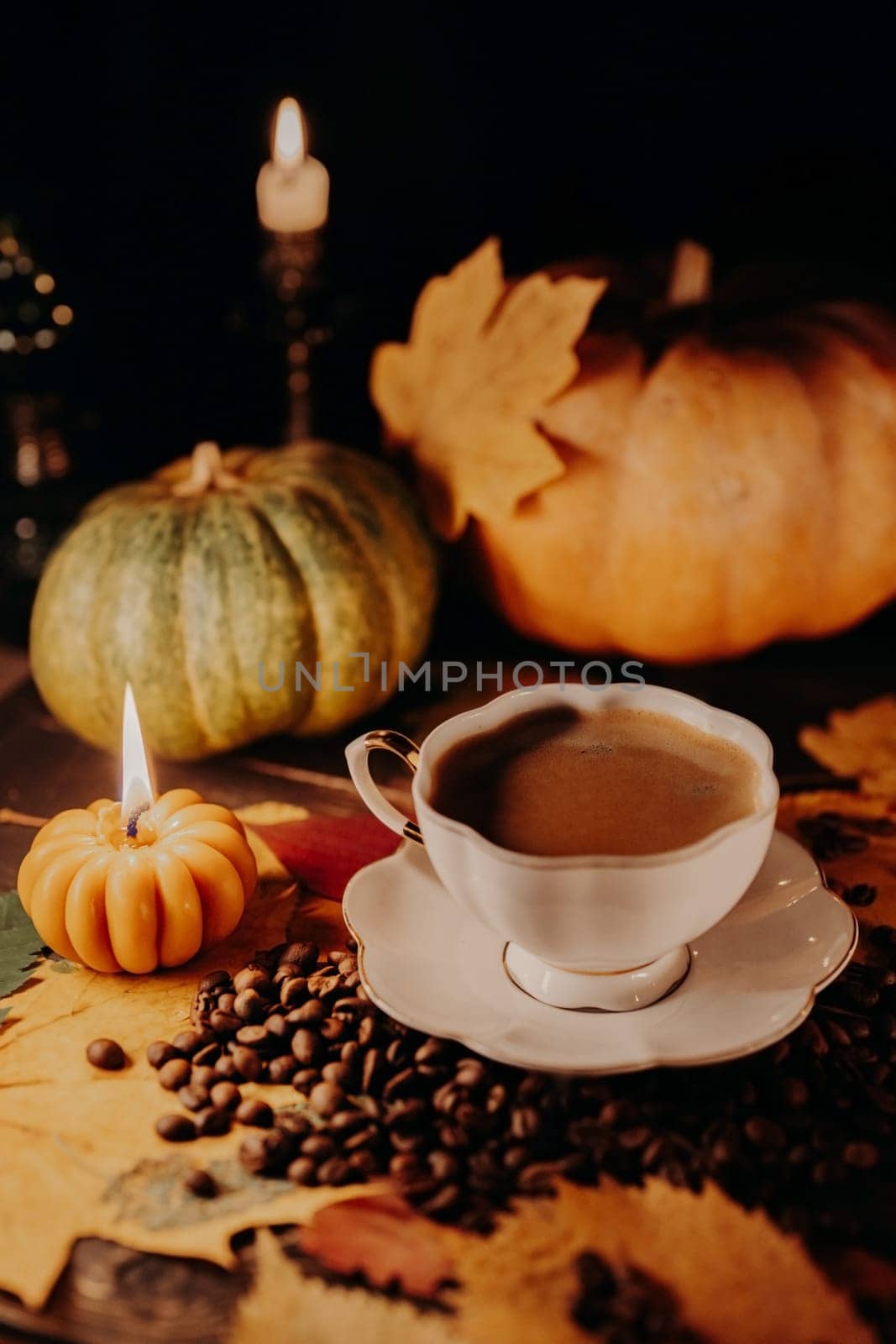 Porcelain coffee cup among pumpkin candles. Autumn-themed content, cafe promotions or visual storytelling that exudes comfort. Touch of intimacy, tranquil and inviting hygge atmosphere.