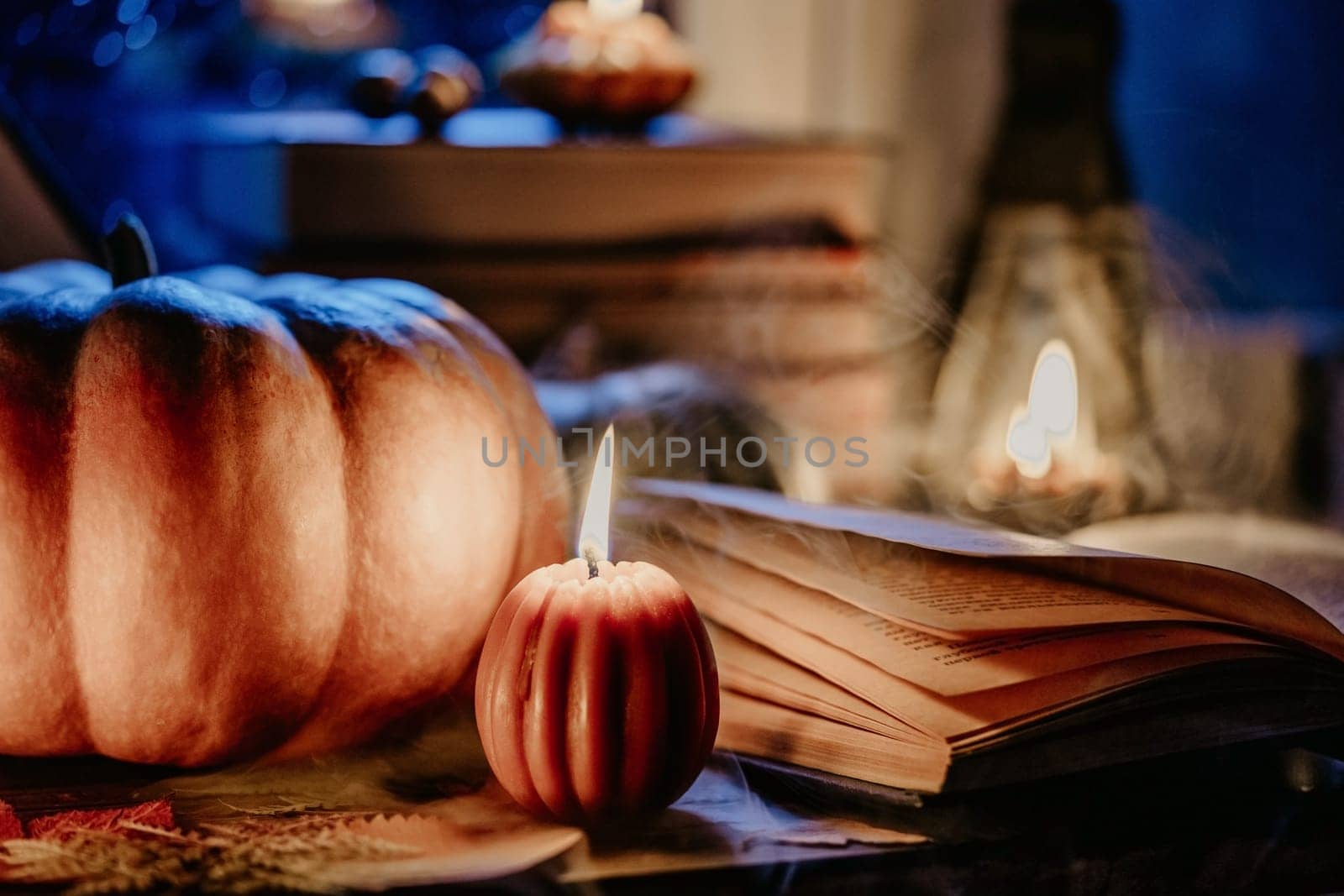 Autumn background. Pumpkin candle burning, open book. Quiet moments, hygge by kristina_kokhanova