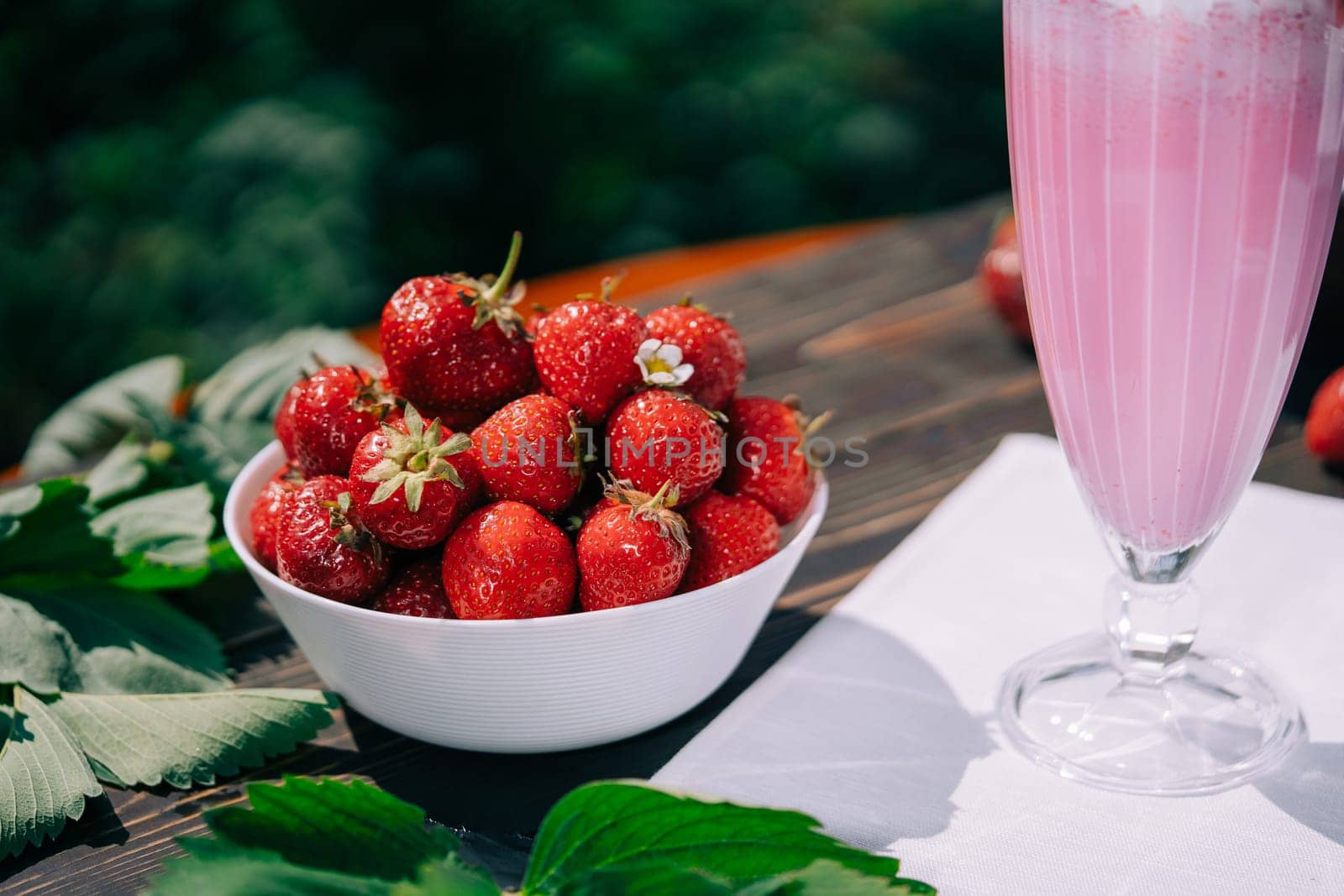 Still life - plate full of strawberries and milkshake cocktail, nature backdrop by kristina_kokhanova