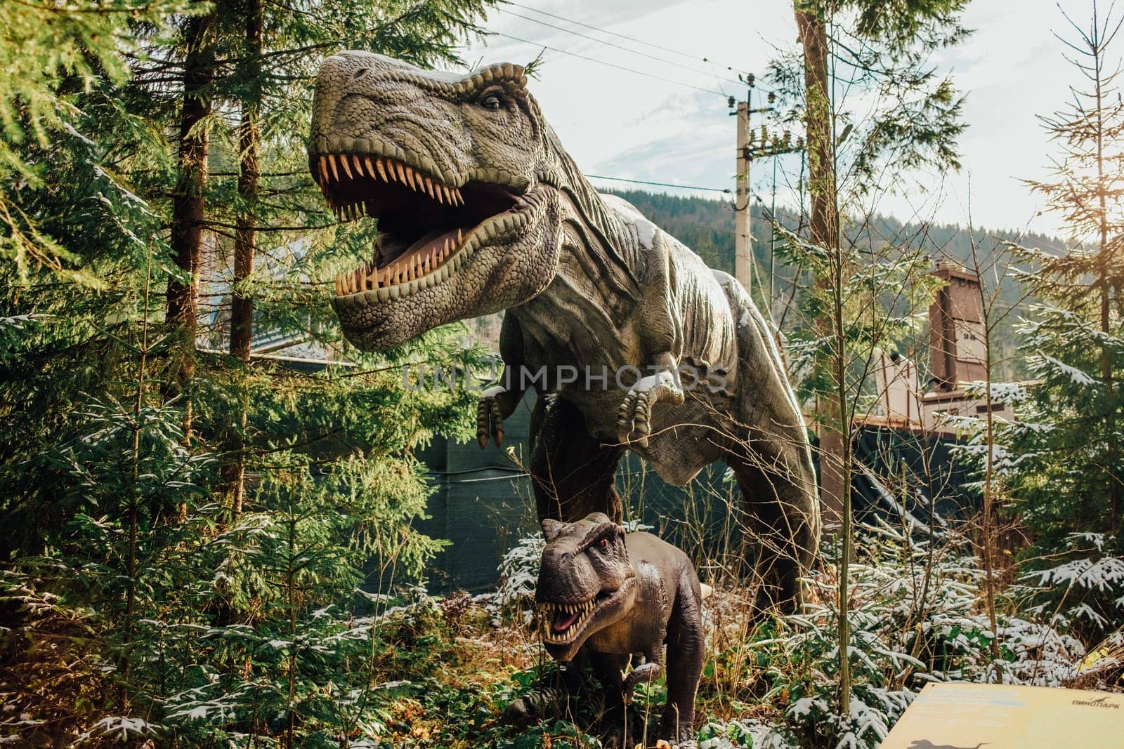 Bukovel, Ukraine - December 2023. Attraction statue of dinosaurs model in Dinopark, winter forest park in nature by kristina_kokhanova