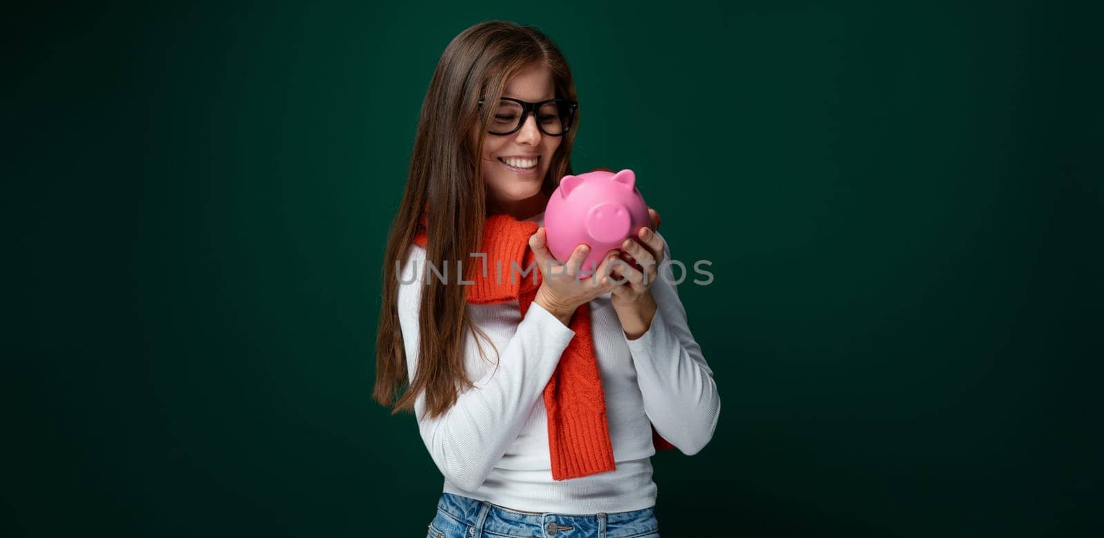 A young woman with brown hair dressed in a white turtleneck protects her savings and stores them in a piggy bank by TRMK