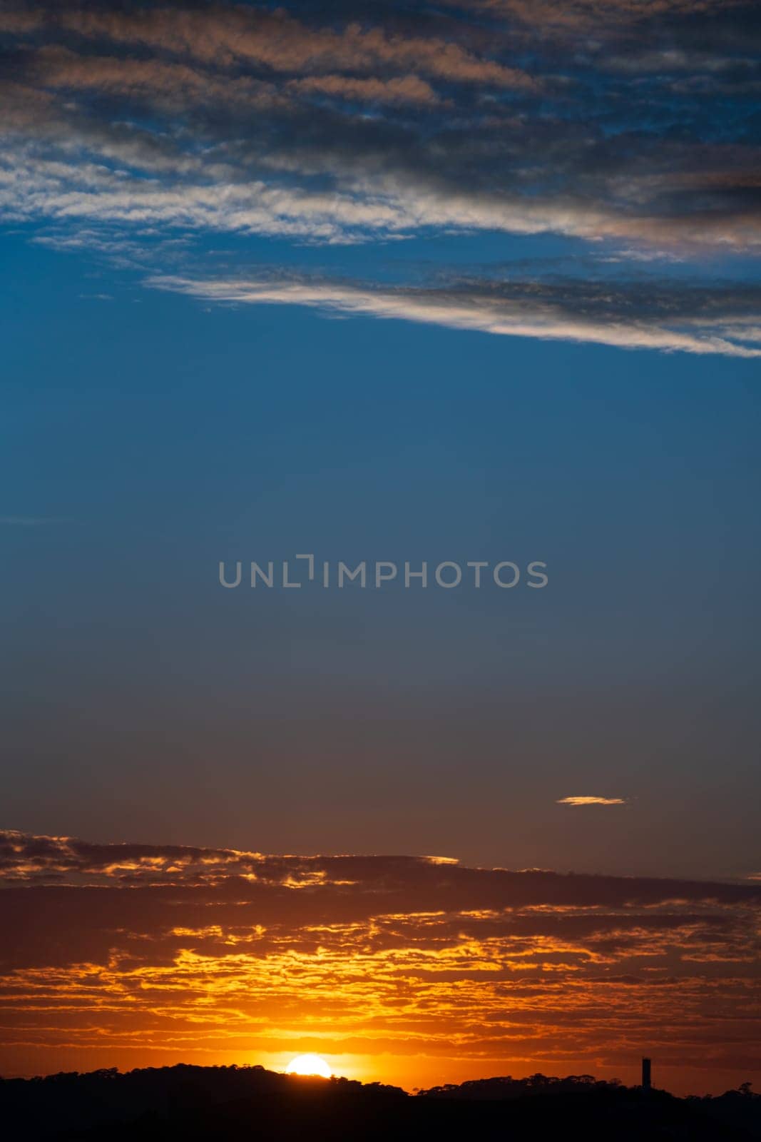 Stunning sunset with the sun setting behind clouds.