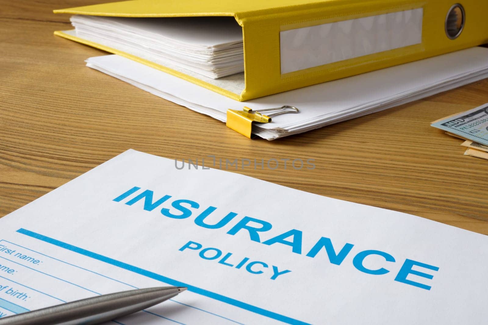 Insurance policy with pen and a folder.