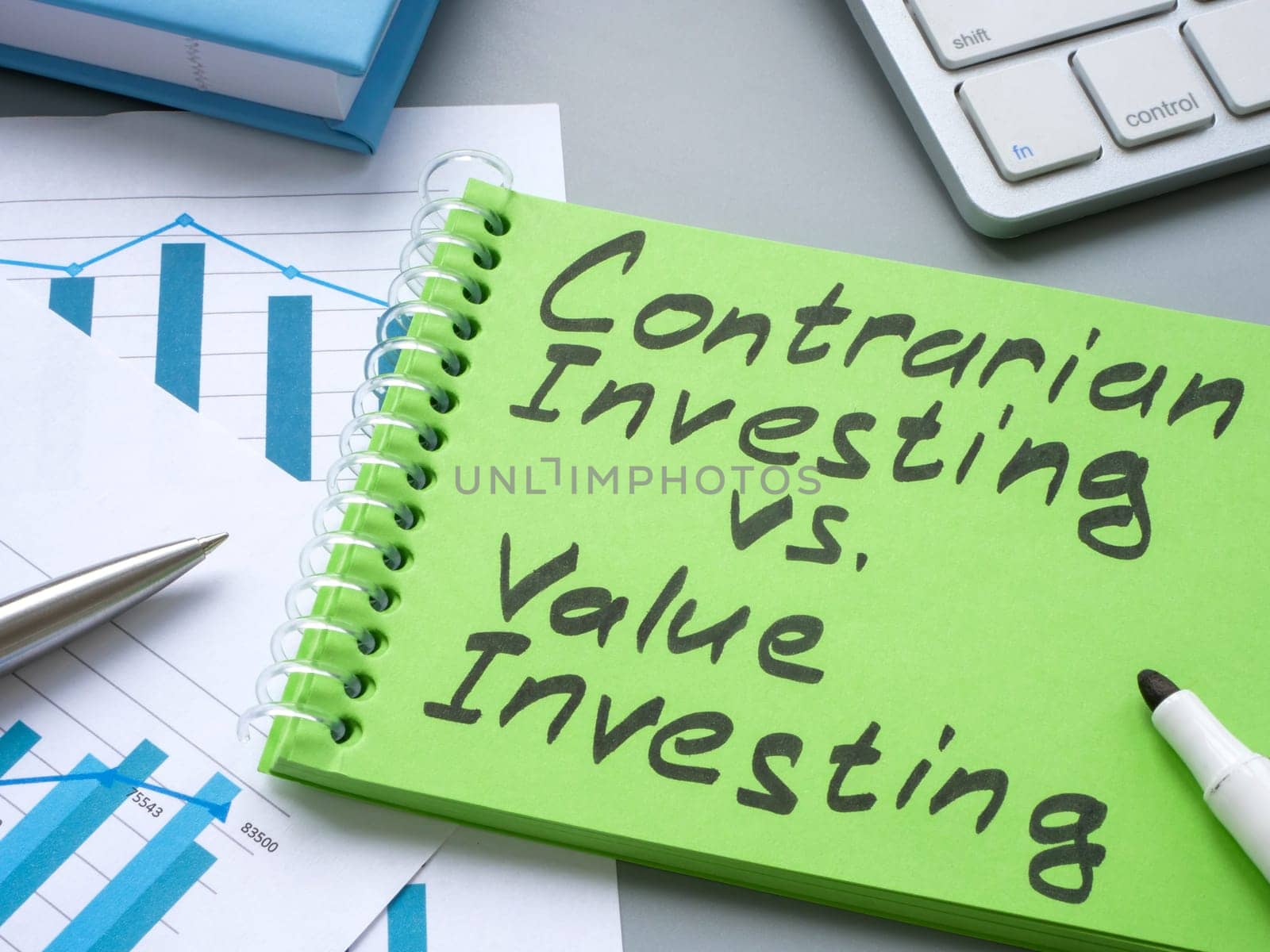 Notepad with sign contrarian investing vs value investing. by designer491
