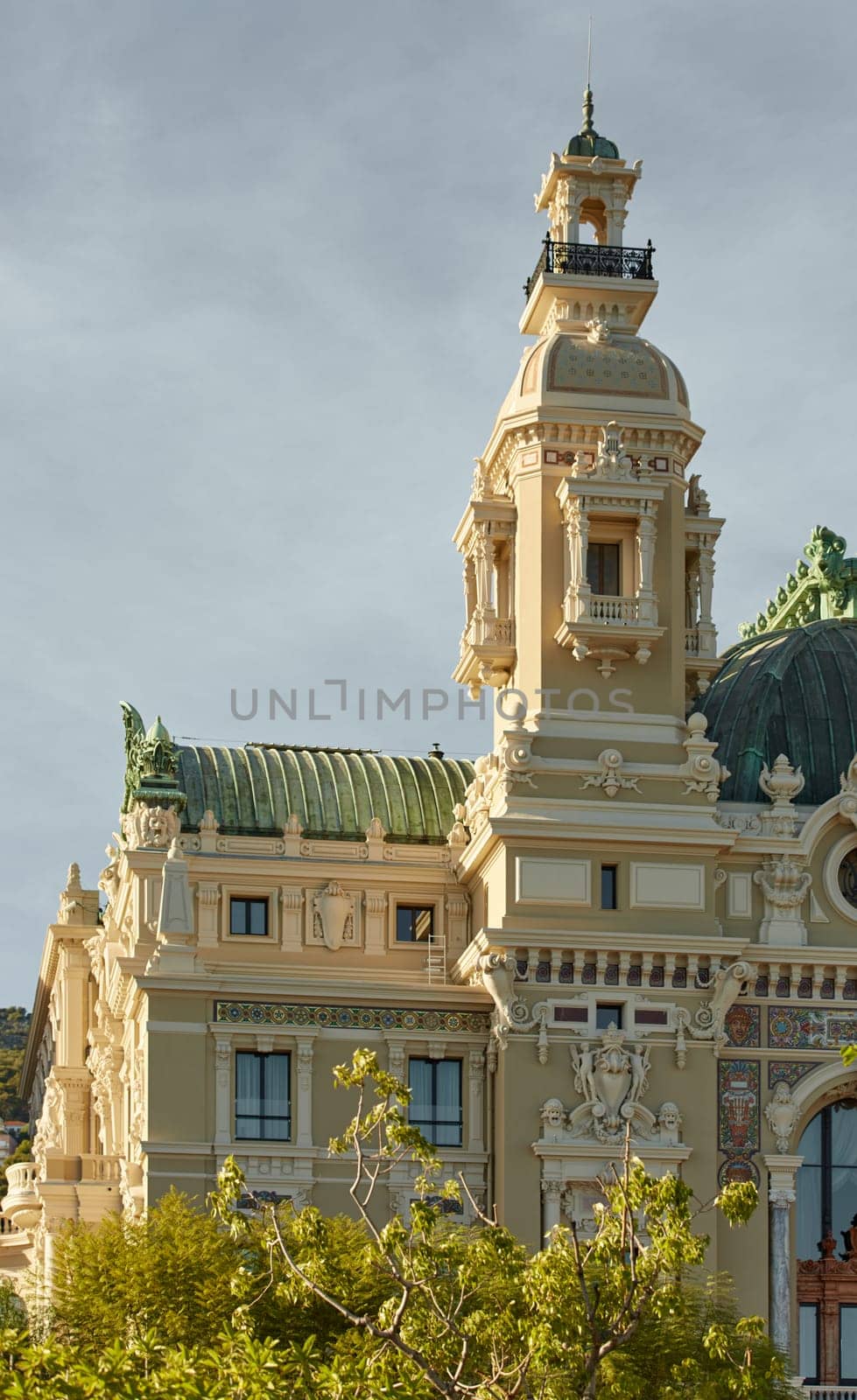 Monaco, Monte-Carlo, 21 October 2022: Tower of Casino Monte-Carlo at sunset, wealth life, famous landmark, pine trees, blue sky by vladimirdrozdin