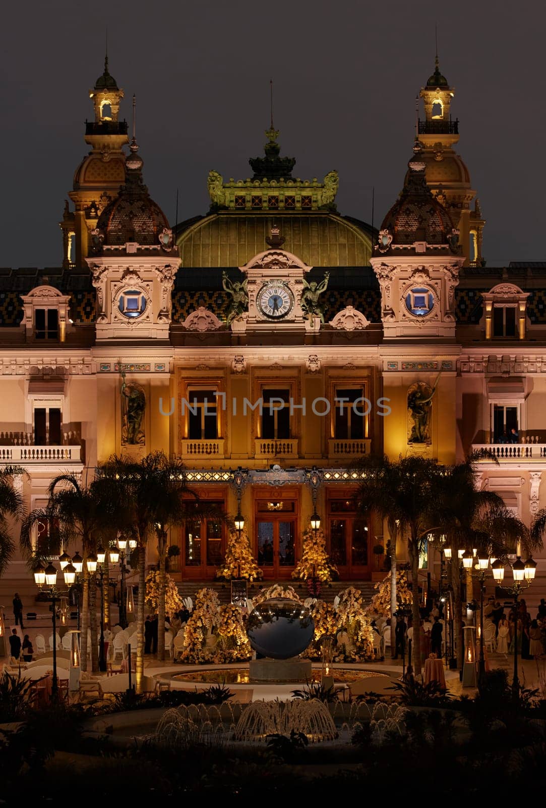 Monaco, Monte-Carlo, 12 November 2022: The famous square of Casino Monte-Carlo is at dusk, attraction night illumination, luxury cars, players, tourists, splashes of fountain. High quality photo