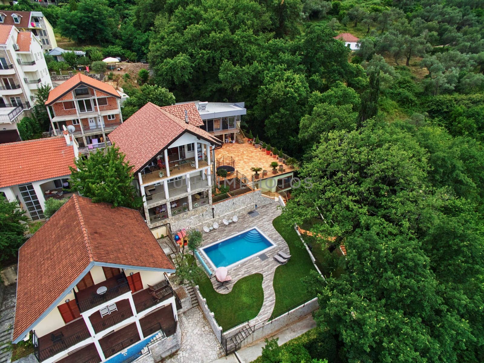 Cozy mansion with a swimming pool among green trees. Drone. High quality photo