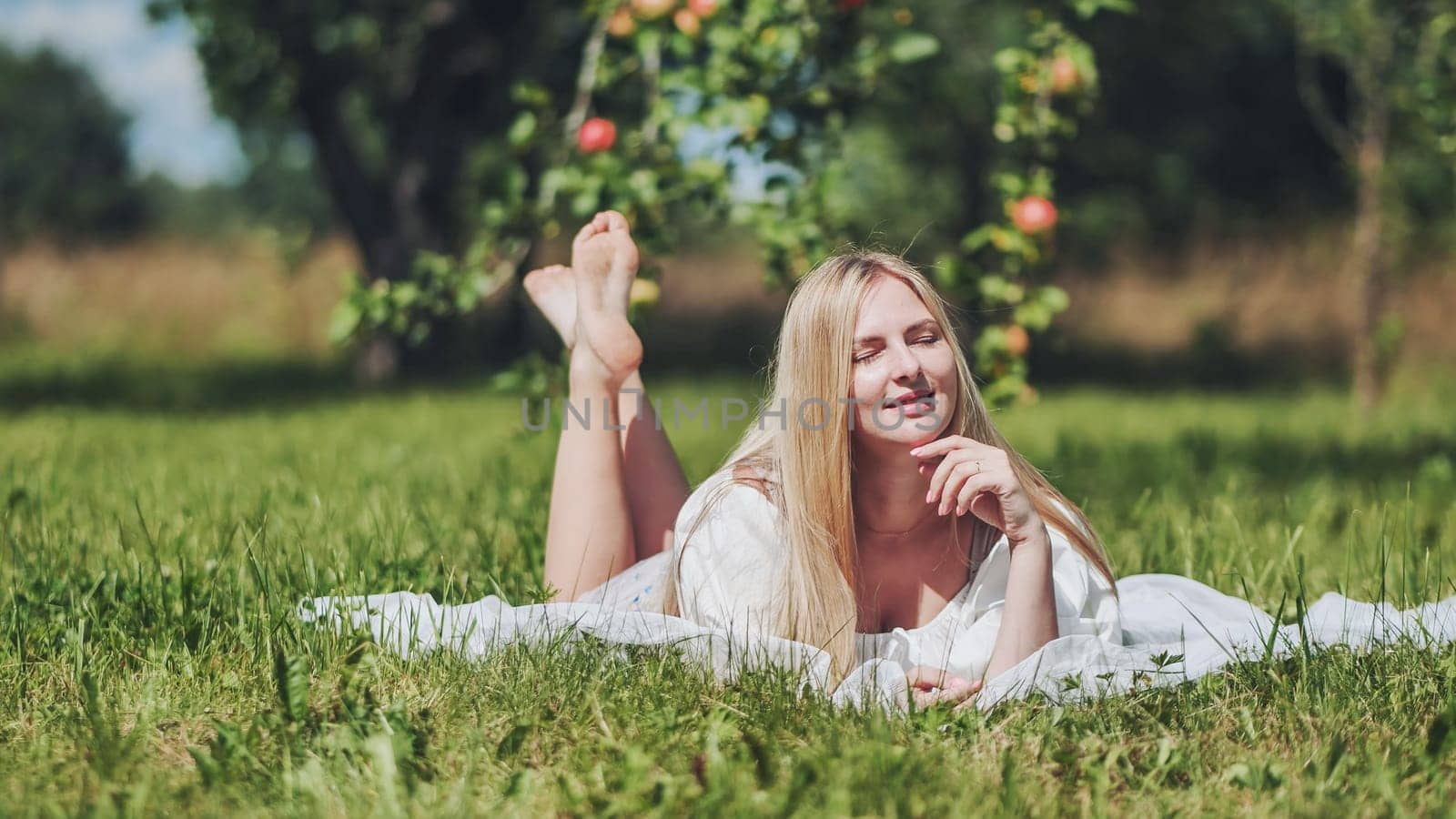 Blonde girl lying in a clearing in the garden