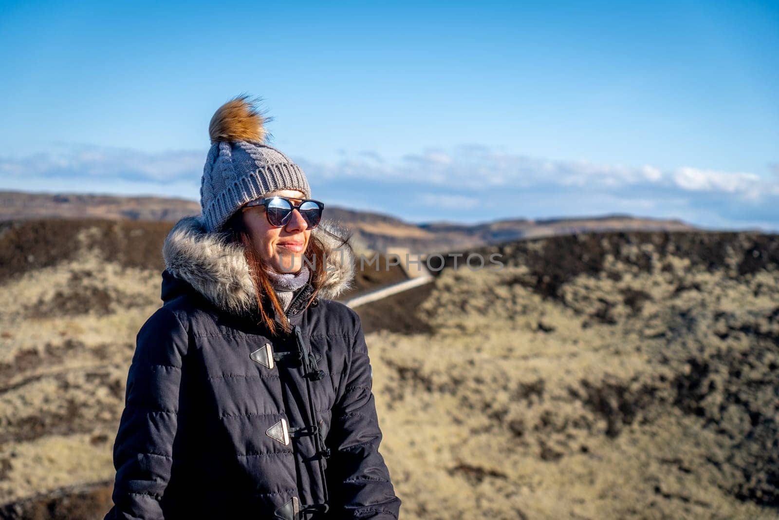 Woman with black coat in a lava field in Iceland