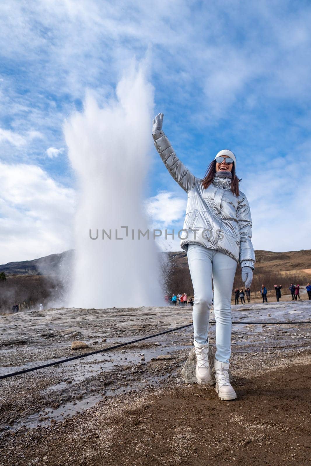 Woman posing with metallic jacket in Geysir, Iceland