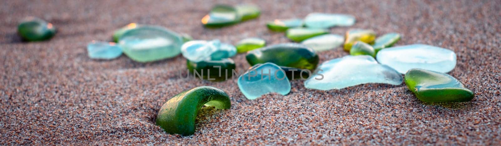 Mediterranean sea beach and glass stones photo. Glass stones from broken bottles polished by the sea. Front view photography with blurred background. High quality picture for wallpaper, travel blog