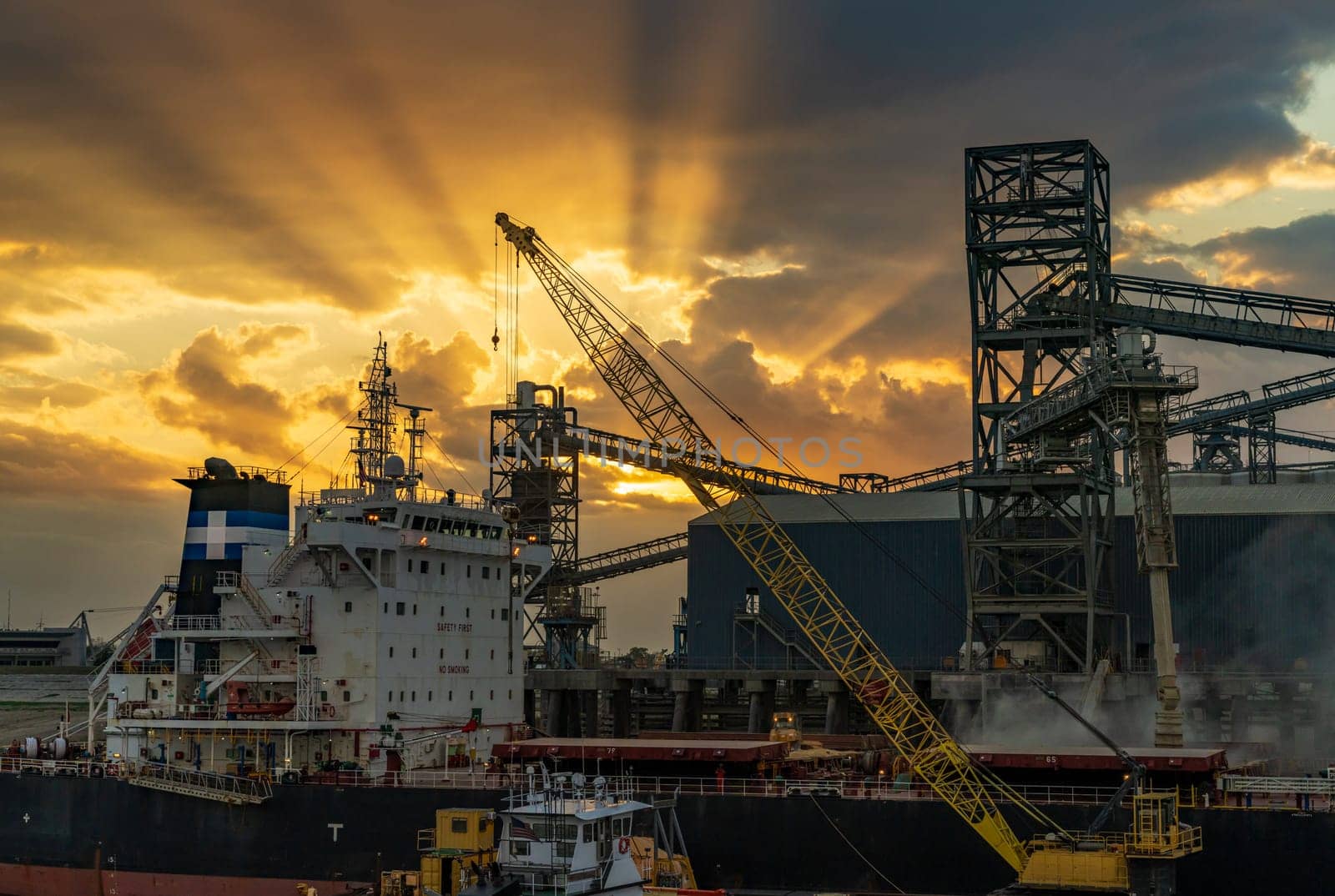 Dramatic sunset over the machinery of loading dock at Port Allen by the Mississippi river in Baton Rouge Louisiana