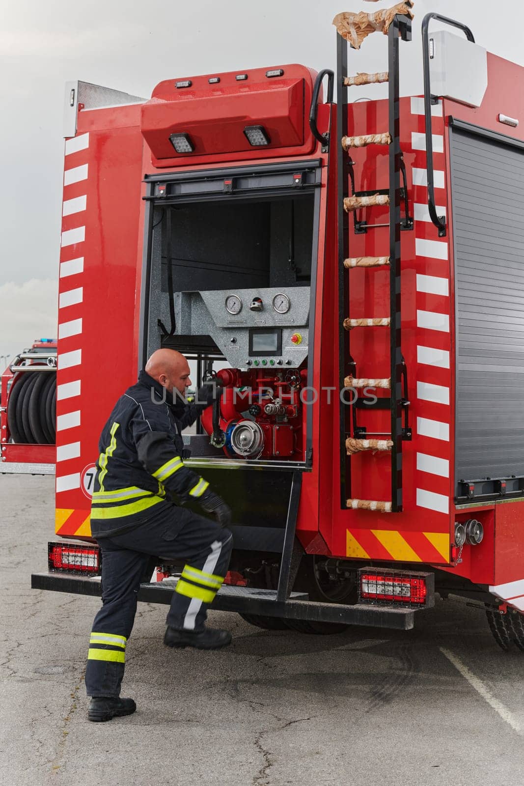 A firefighter meticulously prepares a modern firetruck for a mission to evacuate and respond to dangerous situations, showcasing the utmost dedication to safety and readiness in the face of a fire emergency by dotshock