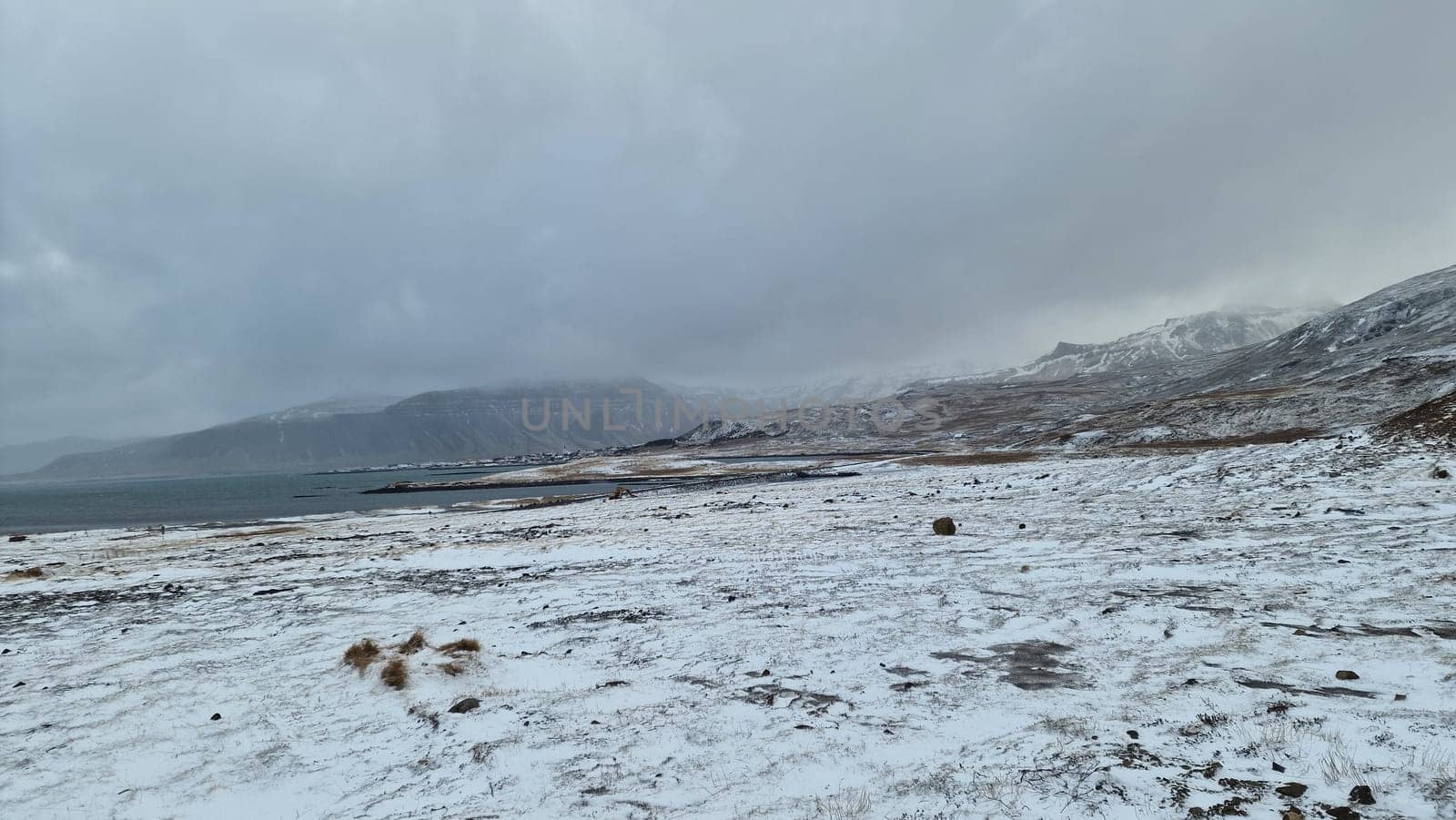 Icelandic region wintery landscape of fields including snow covered mountain peaks and frozen meadows. Frosty highlands, slopes and winter paradise adventure scene compose picturesque setting.