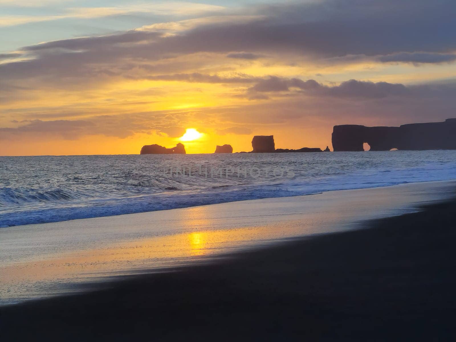 Gorgeous sunset in highlands icelandic region with snow covered rocks and fields, frozen lands in distance. Roadside picturesque beachfront with northern landscape of hills and fields in Iceland.