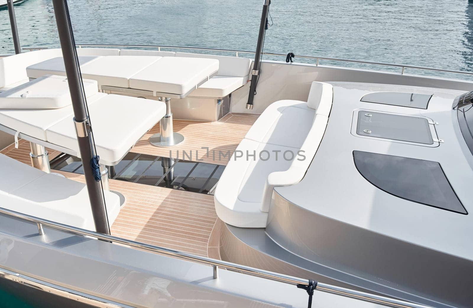 Close-up view of a relaxation area on the open teak deck of an expensive motorboat at sunny day, Monaco yacht show, large boat exhibition, wealth life, table and chairs. High quality photo