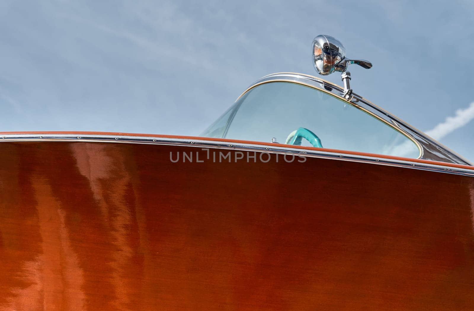 the wooden side of the luxury motor boat in port of Hercules in Monaco, sunny glare of the sun, elegance boat, glossy surfaces shine in sunny weather by vladimirdrozdin