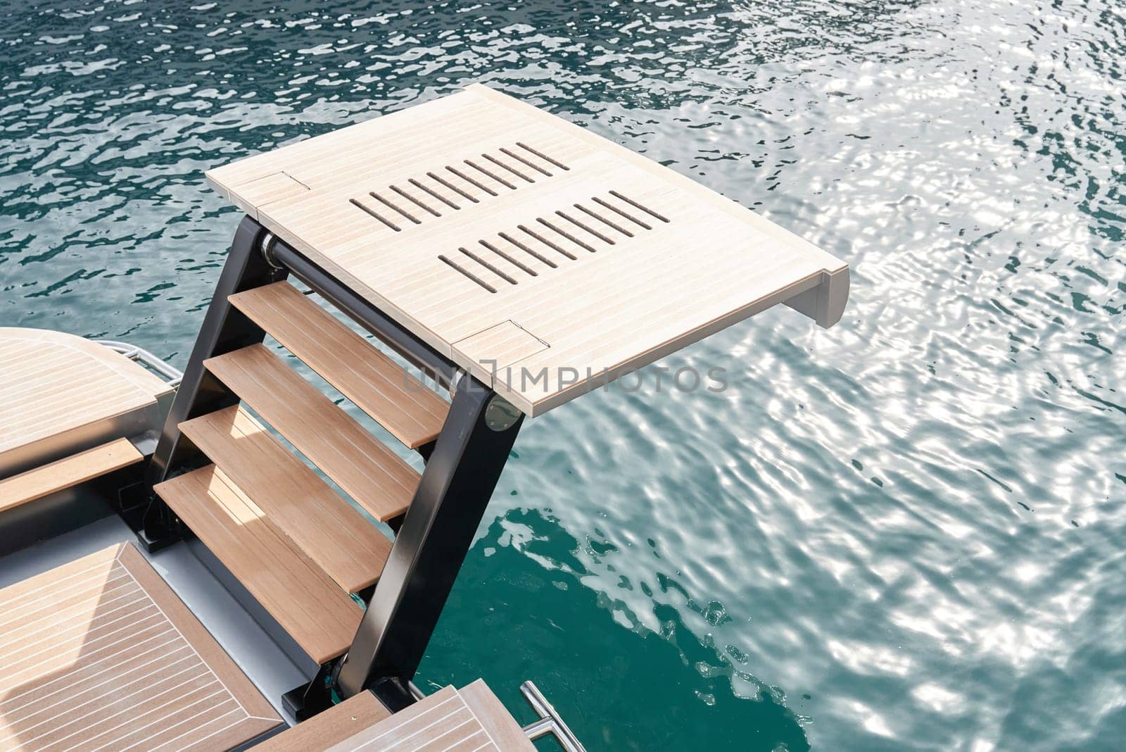 Stern of luxury motor boat with stairs on famous yacht show, exhibition of luxury mega yachts, the most expensive boats, reflections on water. High quality photo