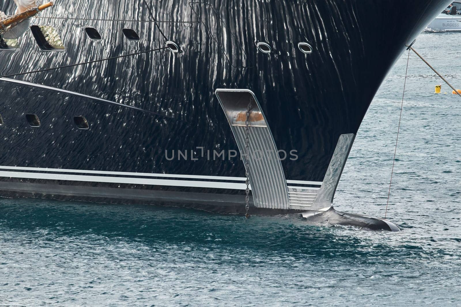 Sun glare on glossy board of mega yacht, anchor, tranquillity in port Hercules, bow of moored huge boat at sunny day, Monaco, Monte-Carlo. High quality photo