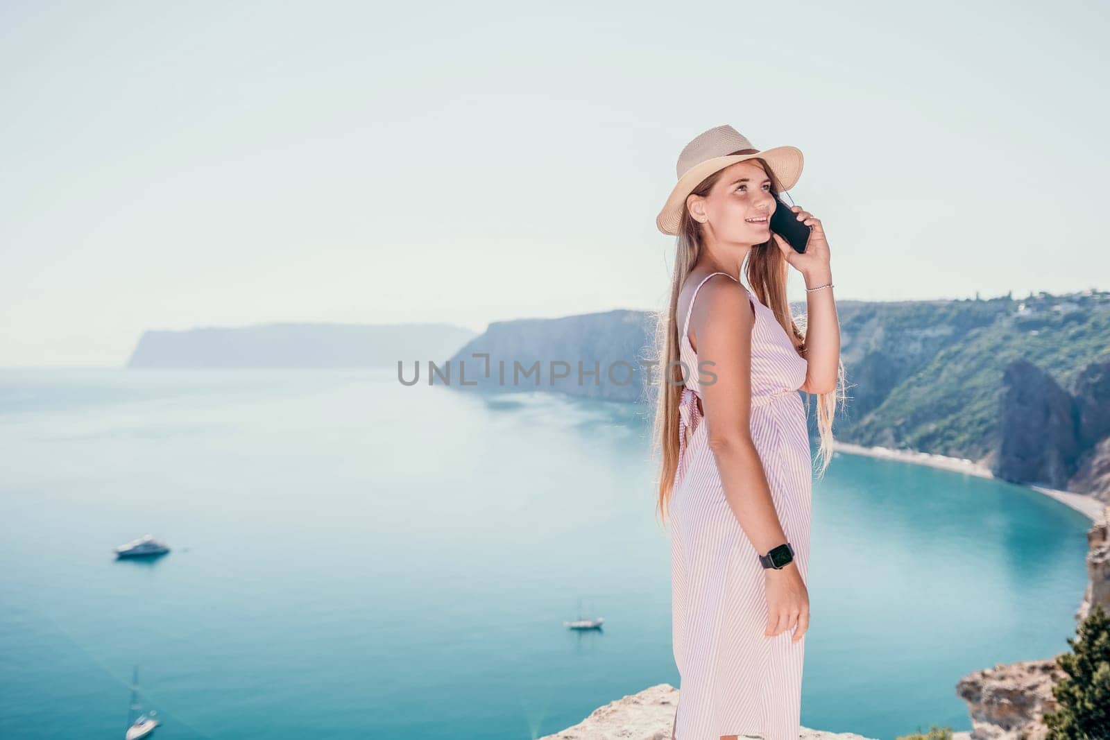 Woman sea laptop. Business woman in yellow hat freelancer with laptop working over blue sea beach. Girl relieves stress from work. Freelance, digital nomad, travel and holidays concept by panophotograph