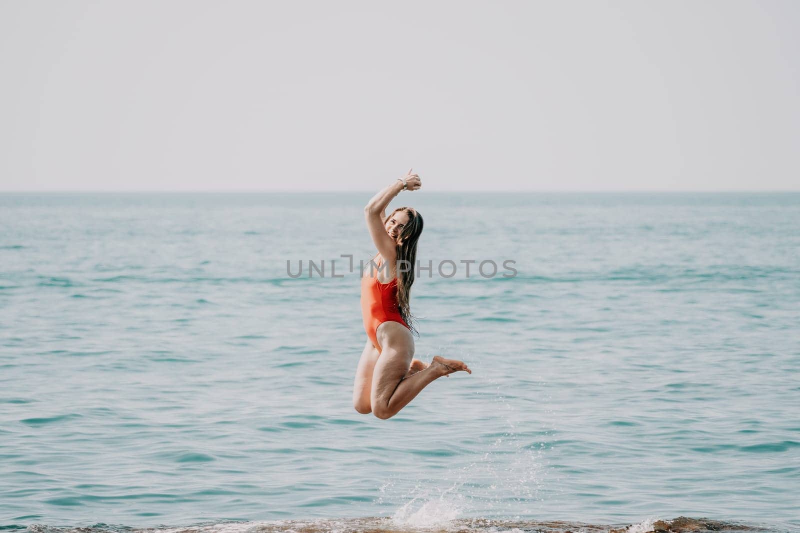 Woman sea yoga. Back view of free calm happy satisfied woman with long hair standing on top rock with yoga position against of sky by the sea. Healthy lifestyle outdoors in nature, fitness concept.