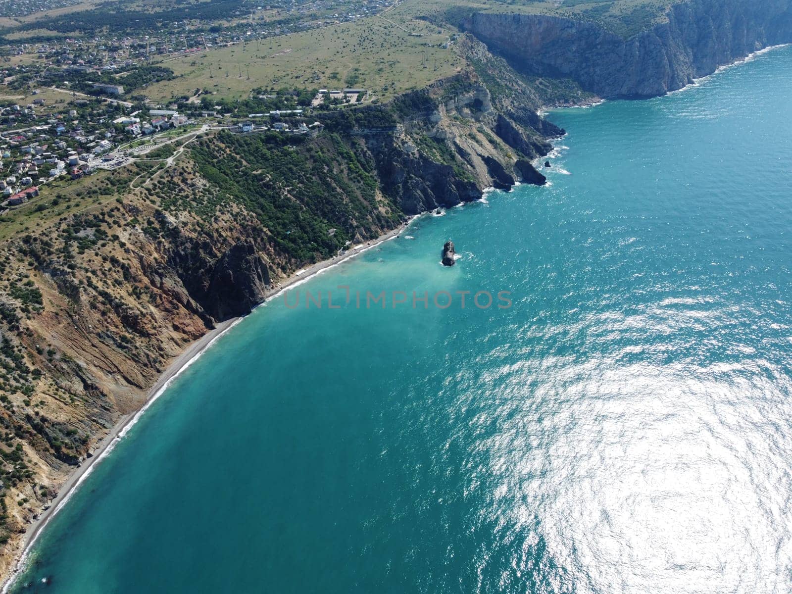 Aerial view from above on calm azure sea and volcanic rocky shores. Small waves on water surface in motion blur. Nature summer ocean sea beach background. Nobody. Holiday, vacation and travel concept by panophotograph