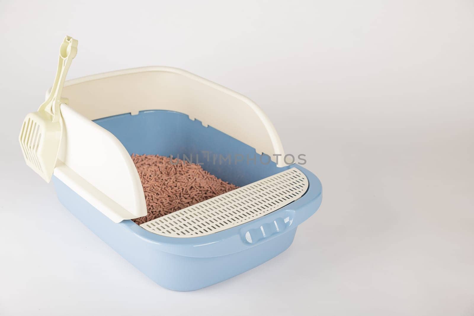 Promote cleanliness and hygiene with an isolated plastic cat litter toilet tray and scoop on a white background. A must-have for your pet's well-being.