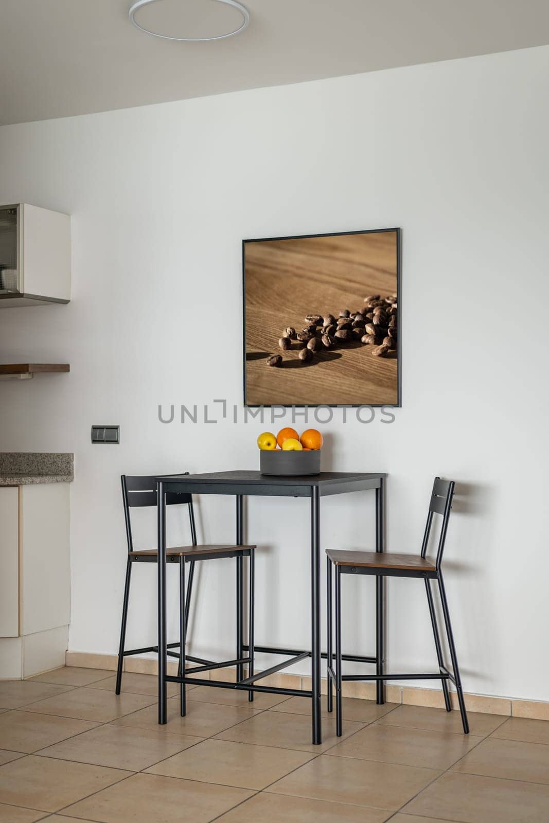 High table with chairs and fruit bowl in dining area by apavlin