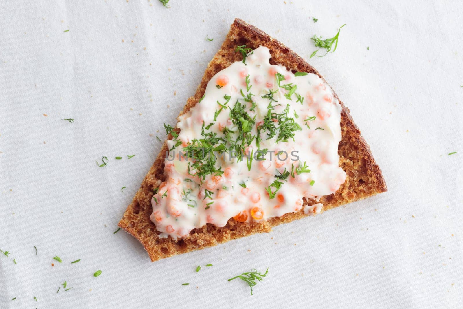 Homemade appetizer with red caviar, sour cream, dill, onion and rye bread on the white table - the traditional finnish recipe for a holiday food, flat lay in minimalistic style, healthy eating concept, horizontal
