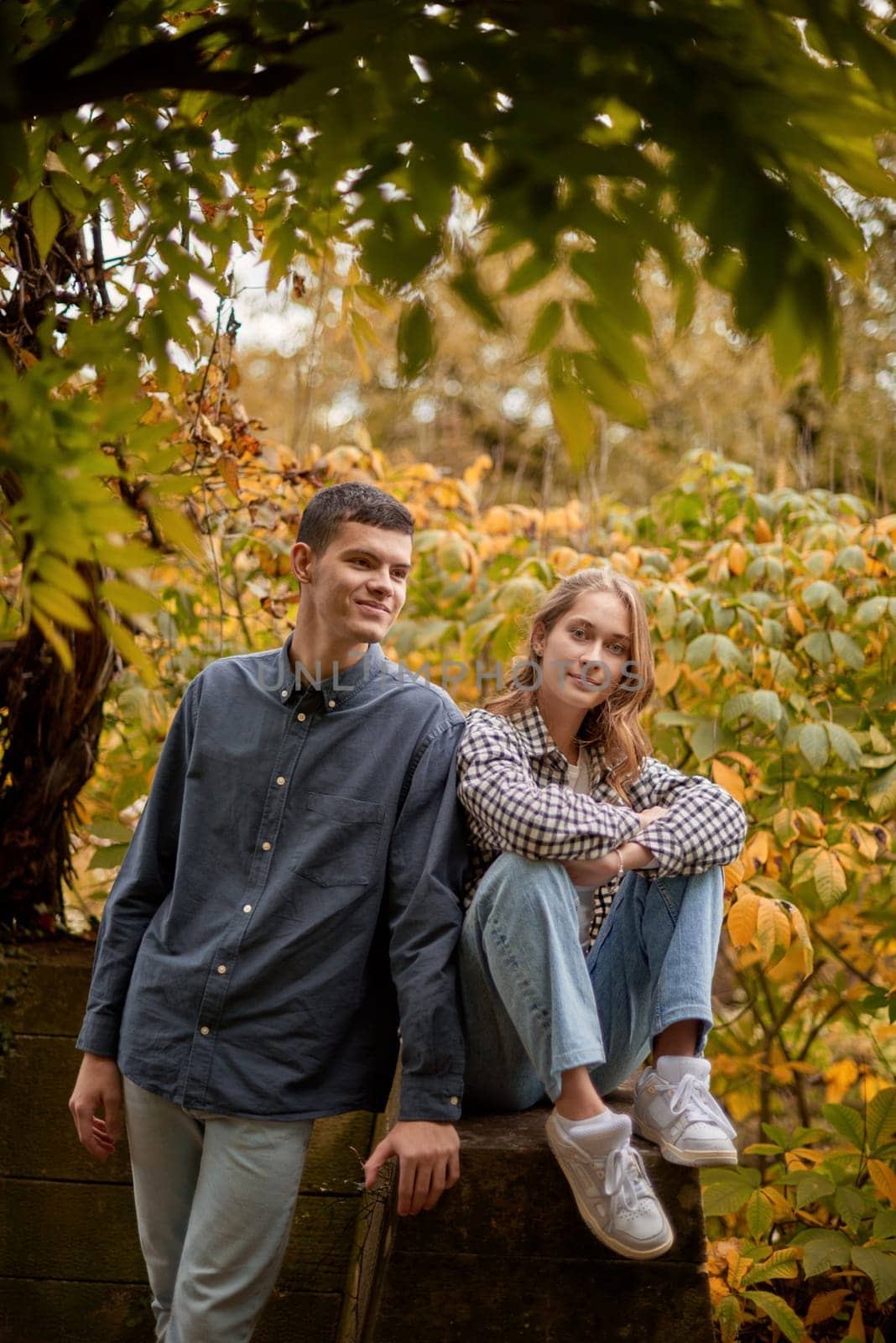 Young Cute Female Hugs Boyfriend. In Autumn Outdoor. Lovers Walking in Park. Attractive Funny Couple. Lovestory in Forest. Man and Woman. Cute Lovers in the Park. Family Concept. Happy Couple.