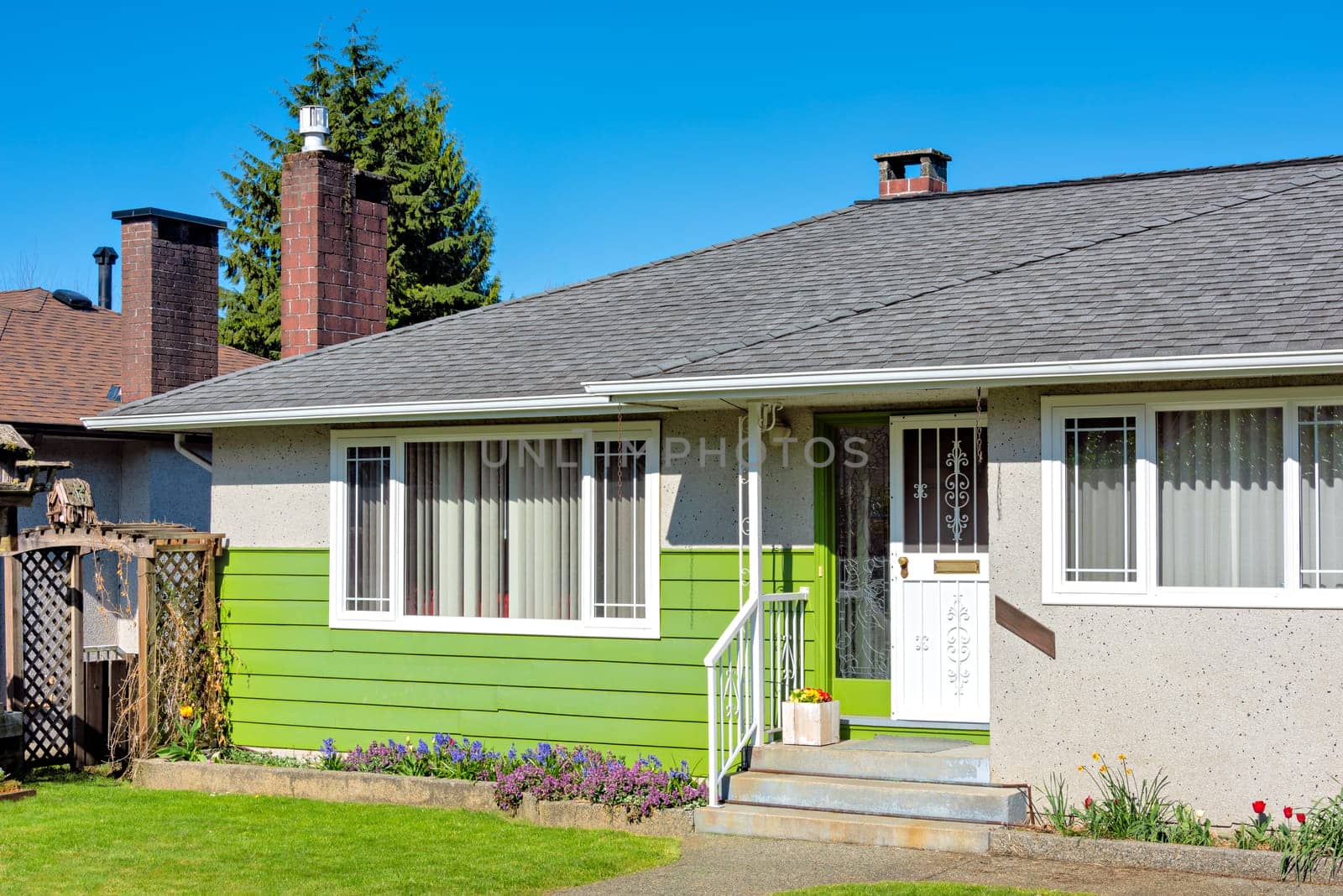 Entrance of residential house with small patio in front on a bright sunny day