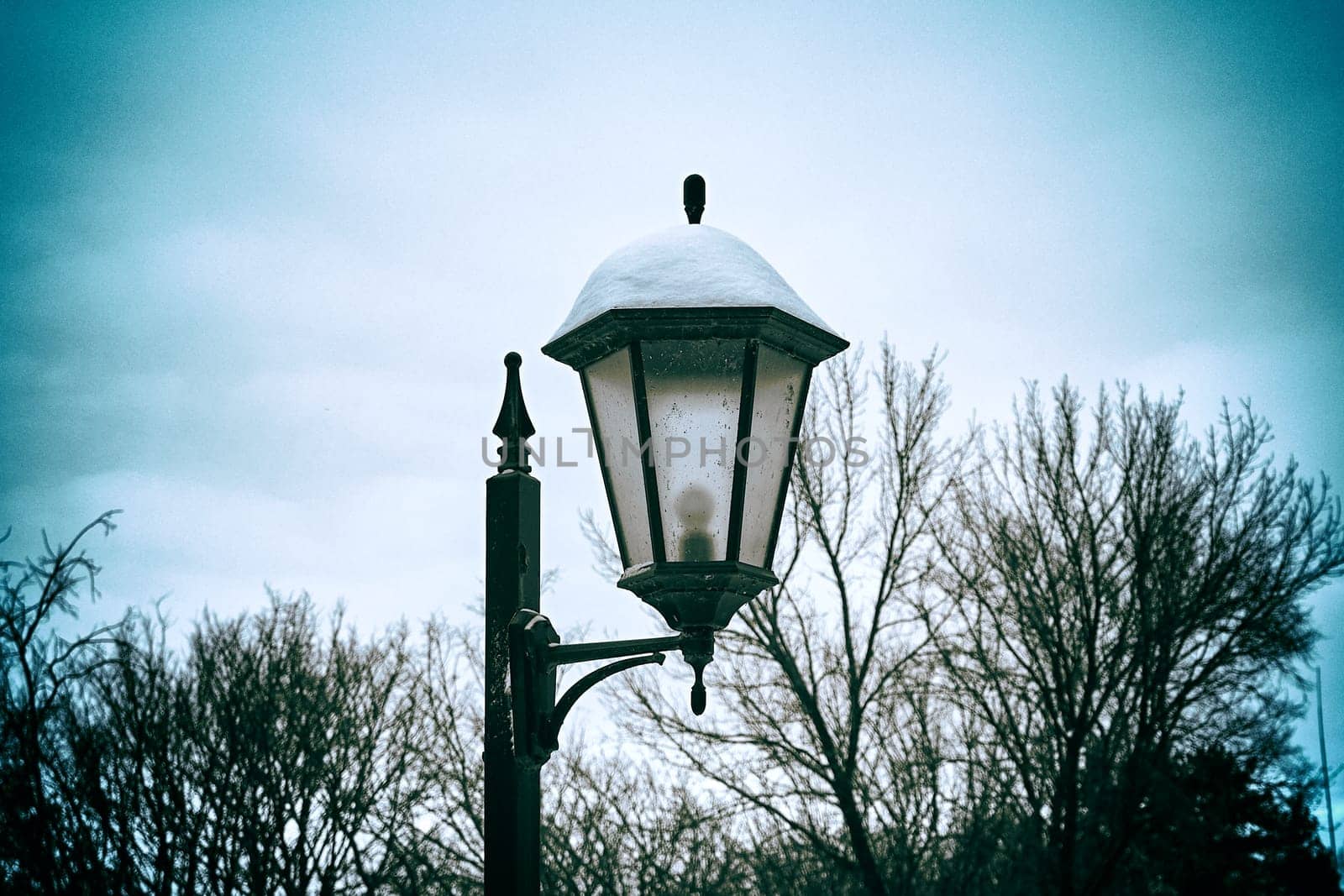 Lantern in the park in winter. Vintage style photo by DAndreev