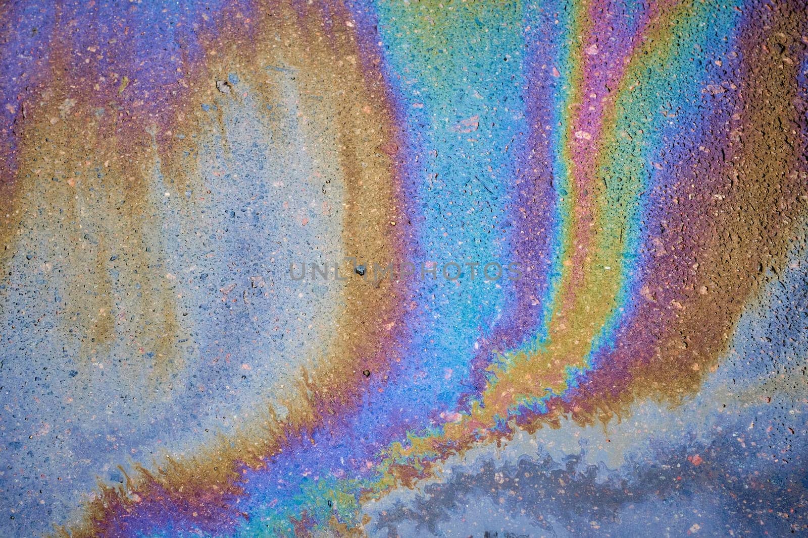 Petrol on the asphalt a big polluted puddle water. A rainbow slick of gasoline