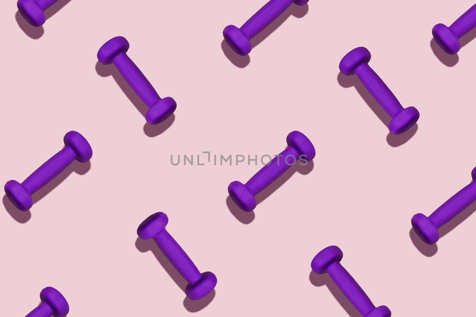 Sports pattern. Purple dumbbells scattered on a pink background.