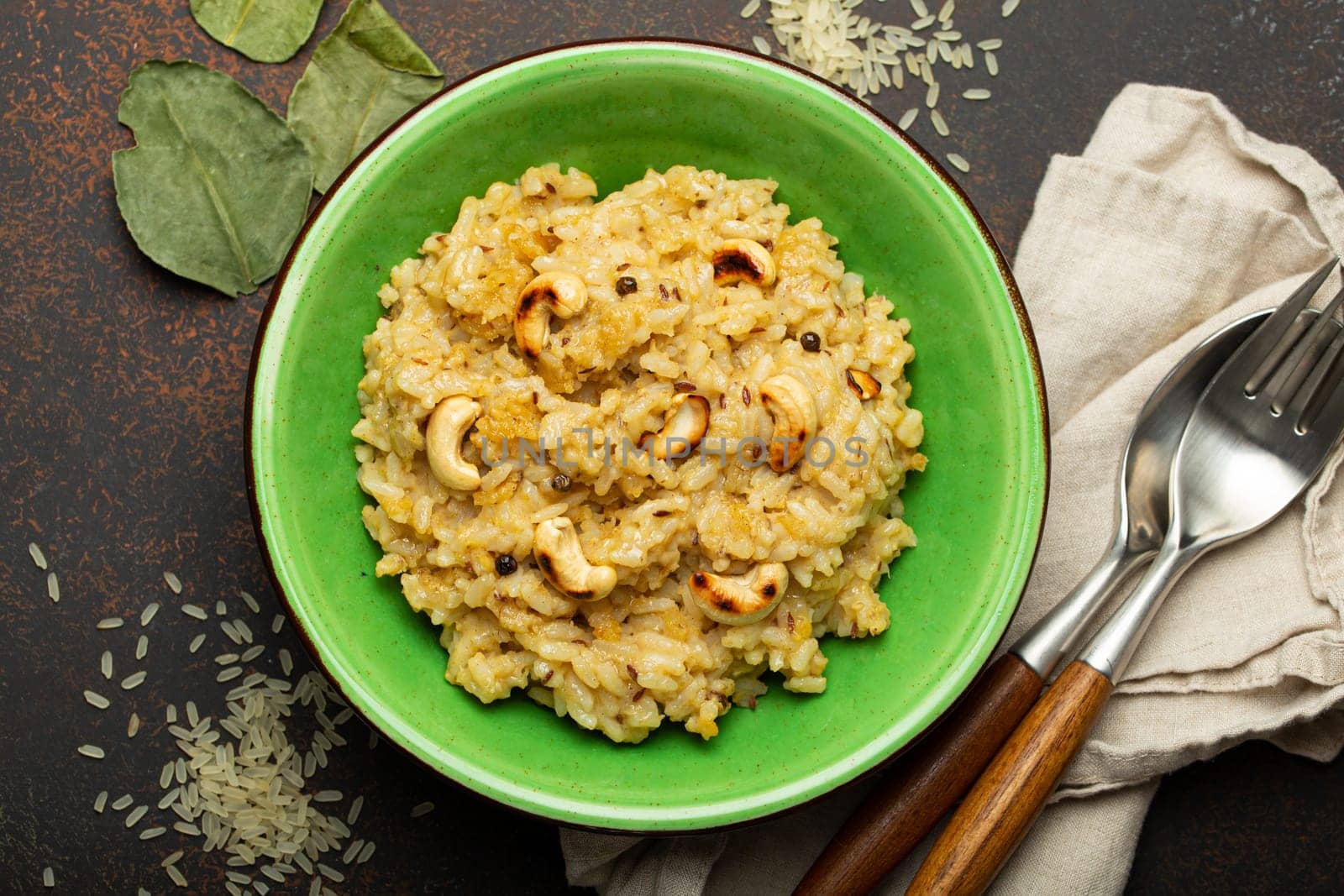 Ven Pongal (Khara Pongal), traditional Indian savoury rice dish made during celebrating Pongal festival, served in bowl top view on concrete rustic background by its_al_dente