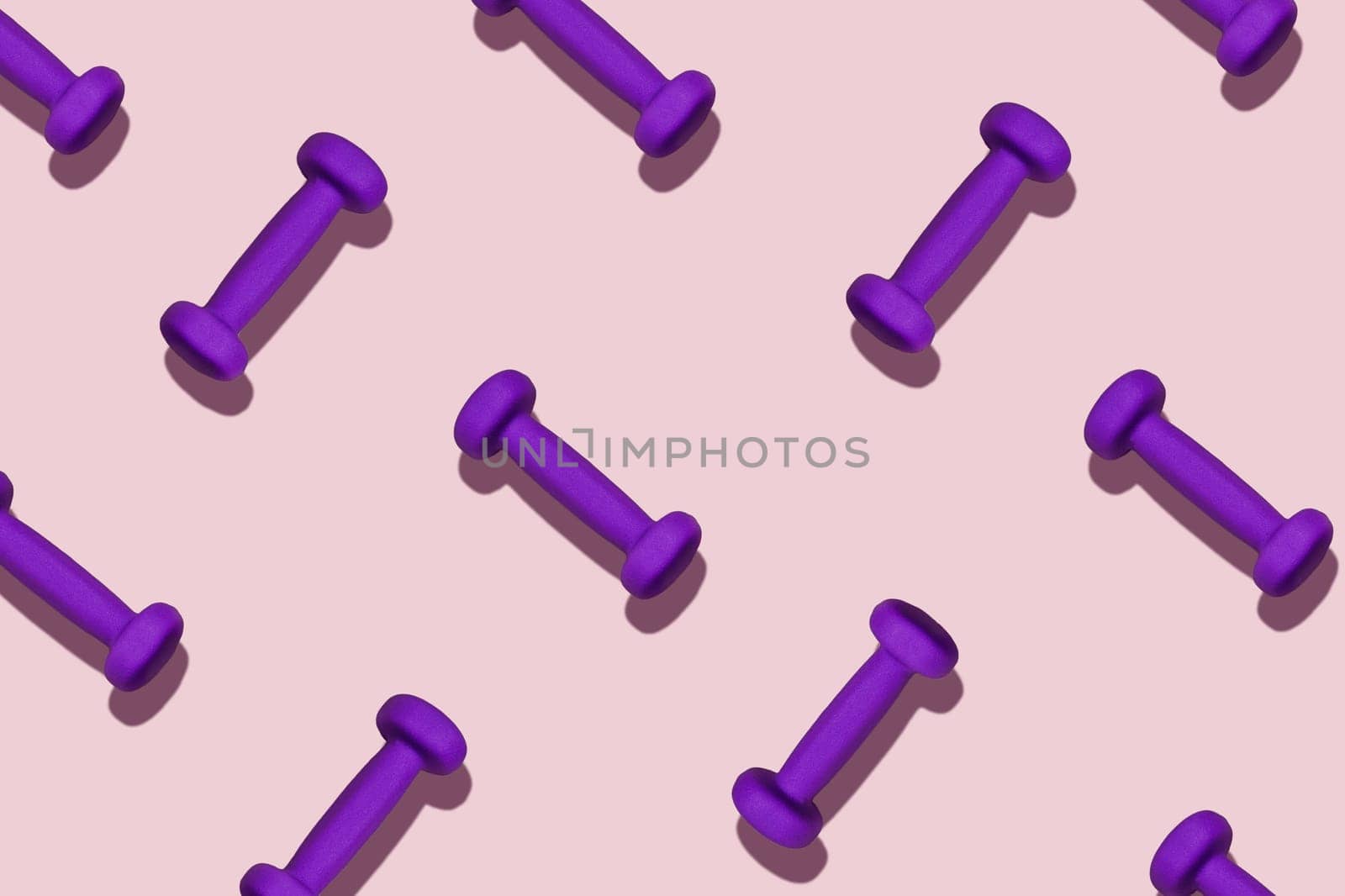 Group of purple dumbbells on a pink background.