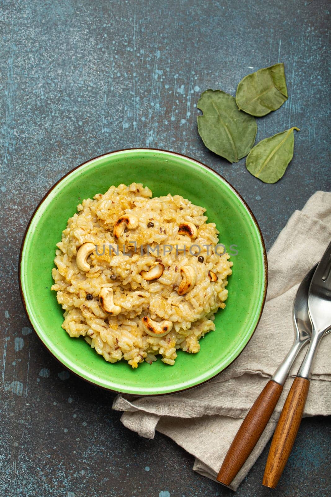 Ven Pongal (Khara Pongal), traditional Indian savoury rice dish made during celebrating Pongal festival, served in bowl top view on concrete rustic background.