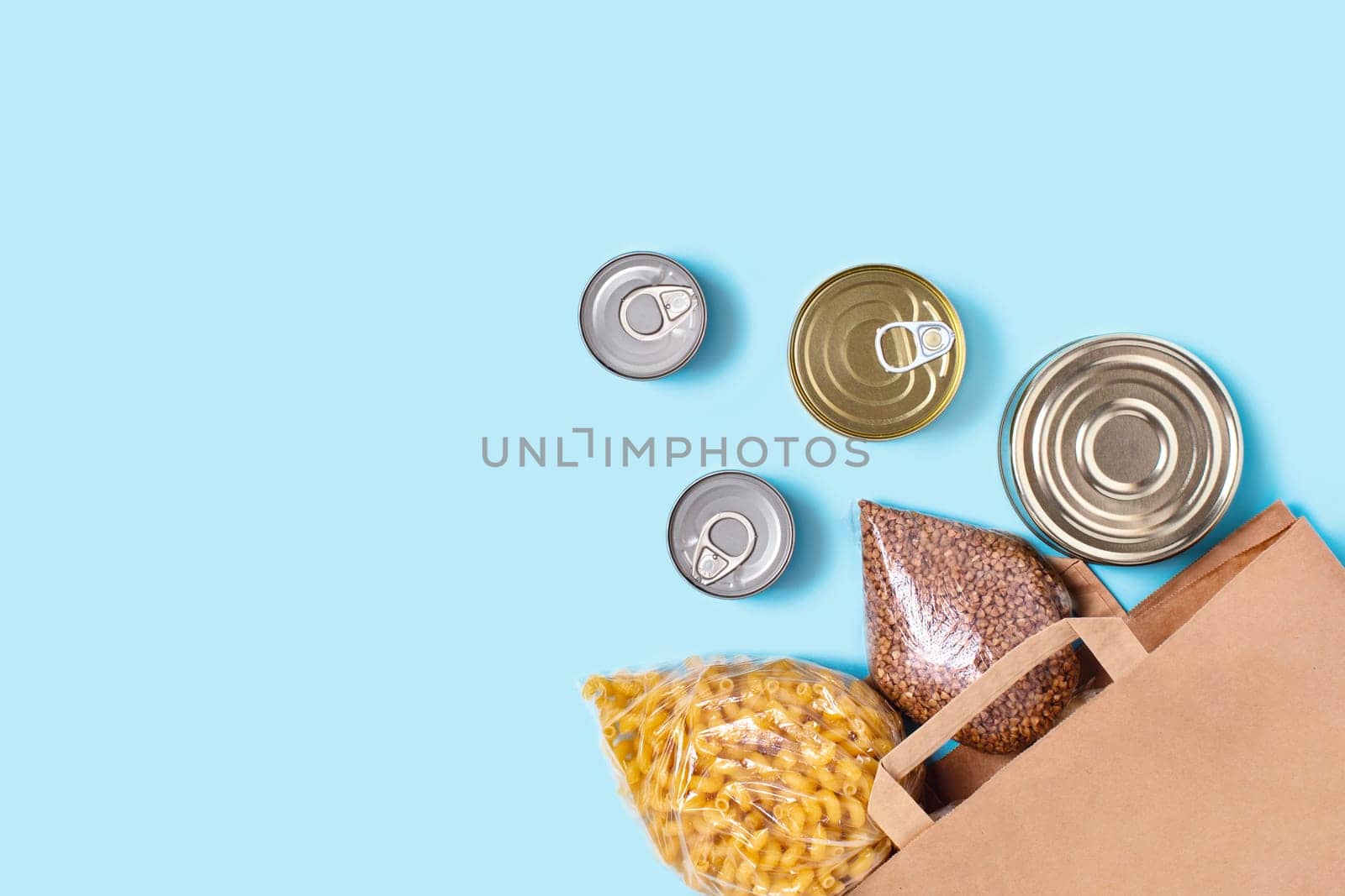 Contactless set of finished product kit. Flat lay with grocery bag on blue background.