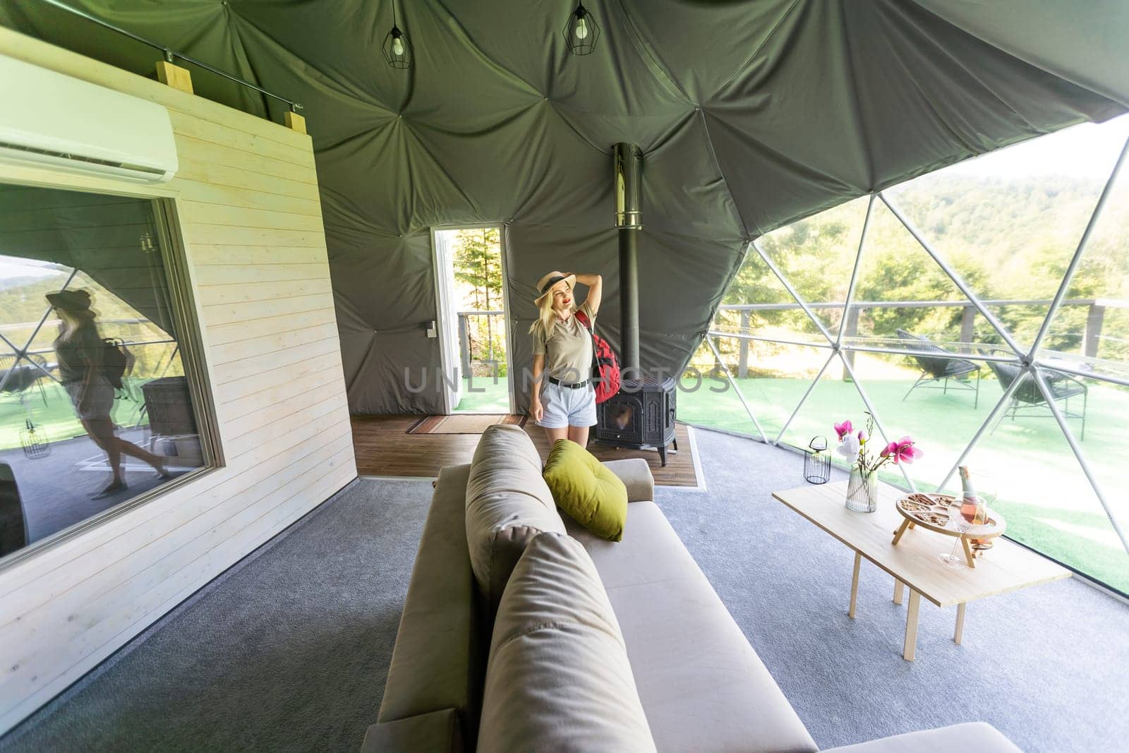 woman inside a geodesic glamping tent.