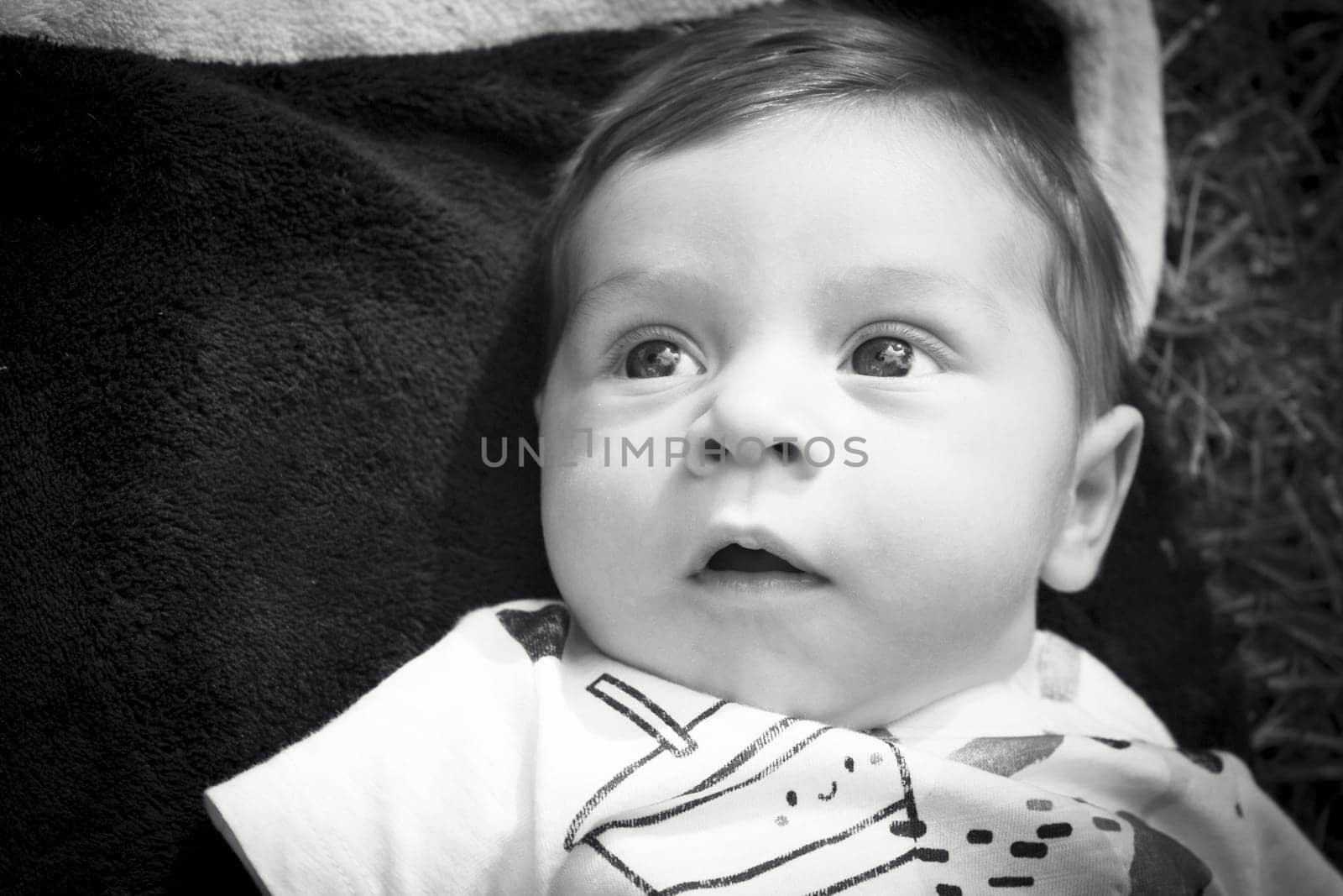 Two month old baby lying on a towel. Happy expression