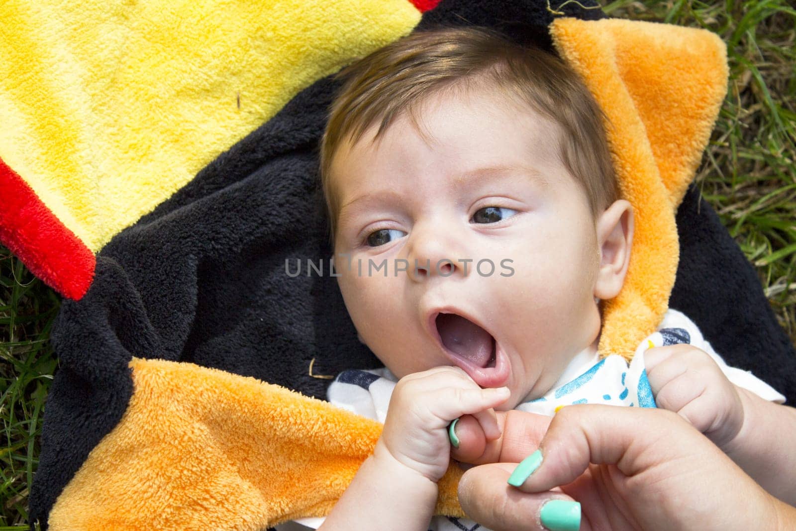 Two month old baby holding his mothers finger. Relax scene