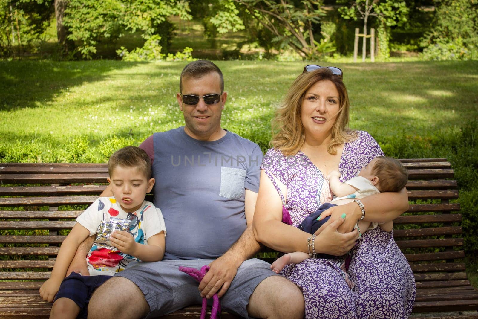 Family sitting on a bench with their stanford dog