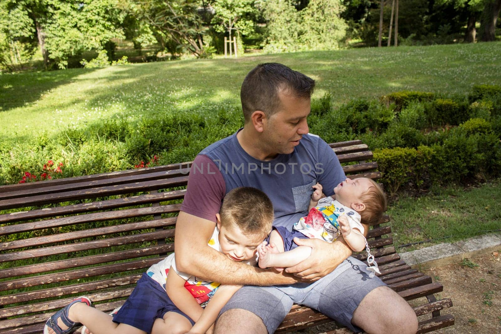 Father with his two sons sitting in a park
